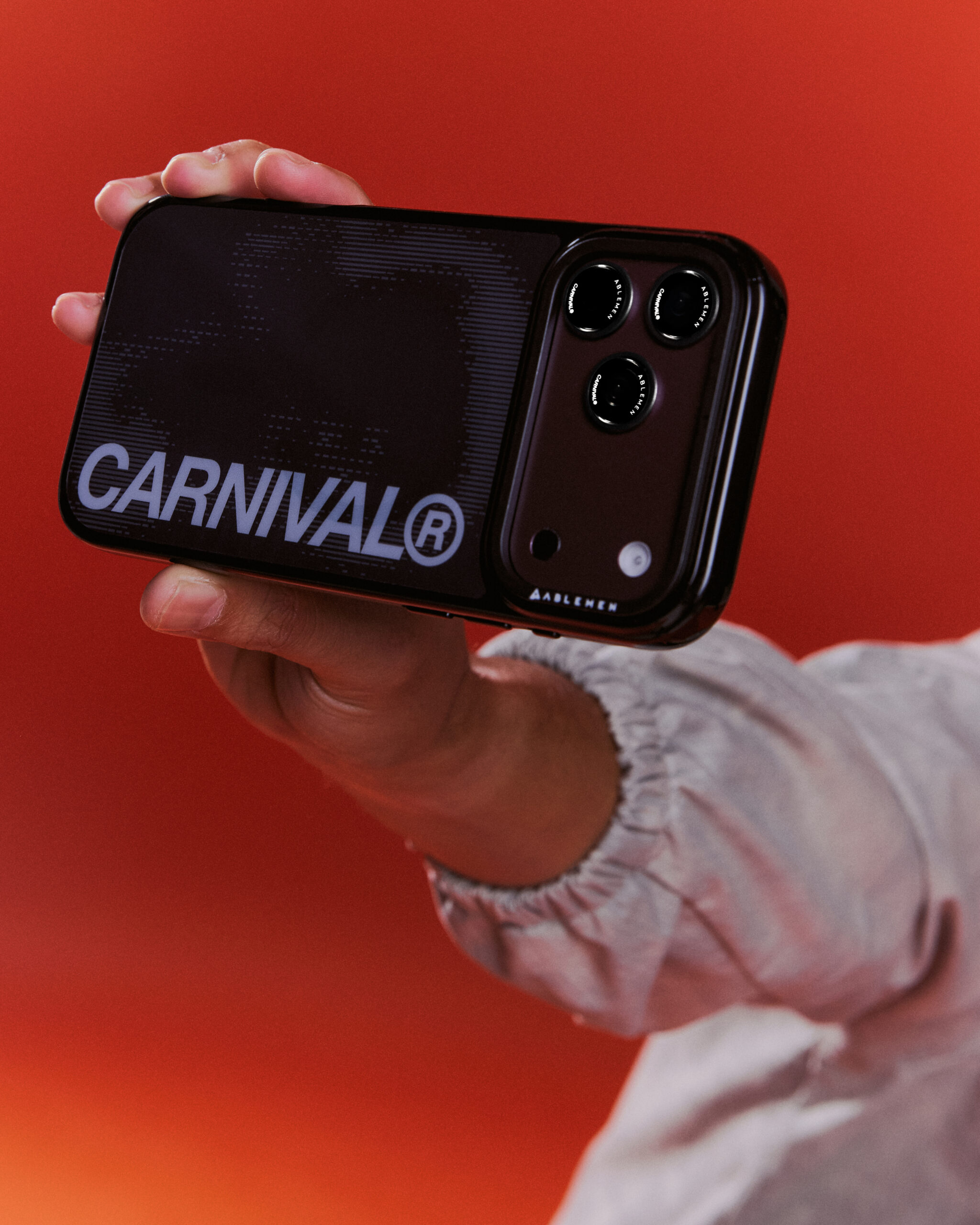ภาพระยะใกล้ของเคสสีดำ ลาย CARNIVAL และขอบปกป้องกล้อง